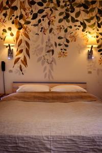 a bedroom with a bed with leaves on the wall at Le Sire de Joux in Montbenoît