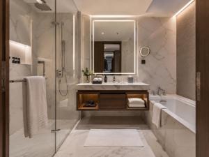 a bathroom with a tub and a sink and a shower at Hotel Platinum Square in New Delhi +23 photos