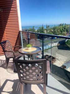 a table and chairs on a balcony with a view of the ocean at AL Mаre in Batumi
