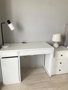 a white desk with a lamp next to a dresser at AL Mаre in Batumi