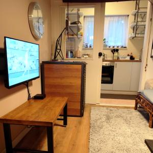 a living room with a tv and a wooden table at Mila Apartment in Skopje +14 photos