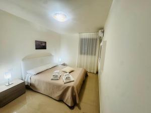 ein Schlafzimmer mit einem Bett, auf dem zwei Handtücher liegen in der Unterkunft FaraHome in Acitrezza