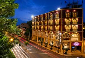 a large building on a city street at night at The Green Park Boutique Hotel and Grand Suites - Chapultepec Parkfront in Mexico City