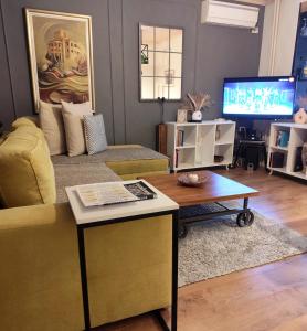 a living room with a couch and a table and a tv at Mila Apartment in Skopje