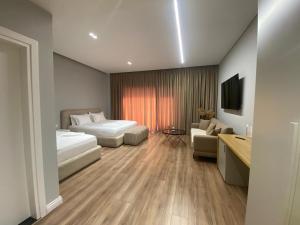 a hotel room with two beds and a couch at Arvi Boutique Hotel in Lukovë