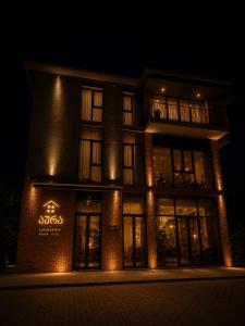 a building lit up at night with lights at Hotel Aura in Zugdidi
