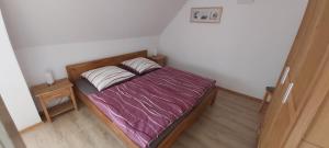 a small bedroom with a bed with a purple blanket at Das Landhaus Wohnung 2 in Kirch Mulsow