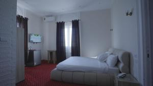 a bedroom with a white bed and a window at New Welcome House Hotel in Alexandria