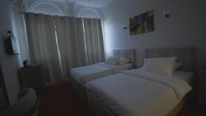 a hotel room with two beds and a chair at New Welcome House Hotel in Alexandria +4 photos