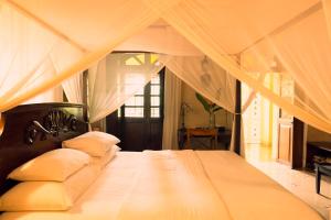 a bedroom with a large bed with white sheets and pillows at Serendipity House Goa in Nerul +83 photos