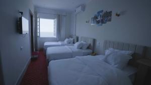 a hotel room with two beds and a window at New Welcome House Hotel in Alexandria