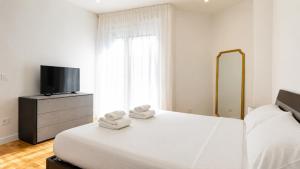 a bedroom with a bed and a tv and towels at Elegantis Luce di Trastevere Apartment with Terrace - Comfort in Most Charming District in Rome