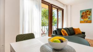 a living room with a table with a bowl of fruit on it at Elegantis Luce di Trastevere Apartment with Terrace - Comfort in Most Charming District in Rome