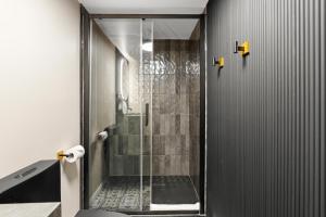 a shower with a glass door in a bathroom at Manoir de la Tour - Par Aneyro in Quebec City +73 photos