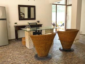a kitchen with a glass table and some chairs at Paseo Kuka by ÓOL Hotels in Holbox Island