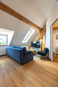 a living room with a blue couch and a television at Apartamenty Centrum - Sunshine in Opole
