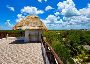 a small hut with a thatched roof on a balcony at Paseo Kuka by ÓOL Hotels in Holbox Island