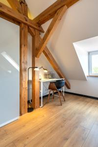 an attic office with a desk and a chair at Apartamenty Centrum - Sunshine in Opole