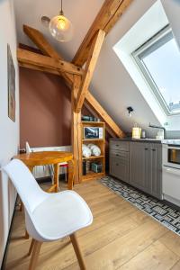a kitchen with a wooden table and a white chair at Apartamenty Centrum - Sunshine in Opole