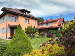 a house with two trees in a yard at Magdelena in Palanga