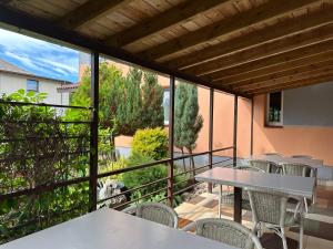a patio with tables and chairs on a balcony at Magdelena in Palanga