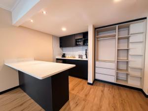 a kitchen with black and white cabinets and a counter at Taormina Hotel y Casino in San José +17 photos