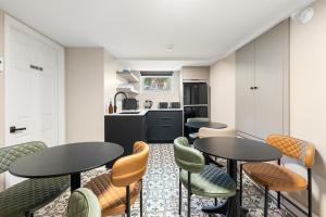 a room with two tables and chairs and a kitchen at Manoir de la Tour - Par Aneyro in Quebec City