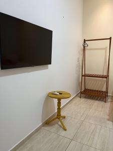 a small table in a room with a television on a wall at Vila da Andrea in Barreirinhas