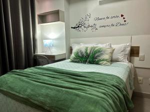 a bedroom with a bed with a green comforter at 2802 Unique · Studio Unique c/ garagem in Belém