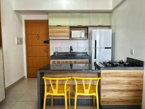 a kitchen with two yellow chairs at a counter at 2802 Unique · Studio Unique c/ garagem in Belém +21 photos