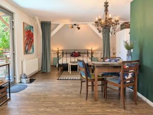 a dining room with a table and chairs and a bed at Ferienwohnung im Loftstil in Hemmoor
