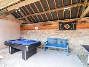 a ping pong table and a blue bench in a room at Granary in Pickering