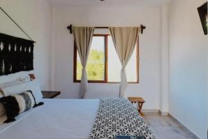 a bedroom with a large bed and a window at Paseo Kuka by ÓOL Hotels in Holbox Island +47 photos