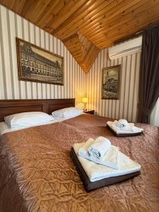 a bedroom with a large bed with towels on it at Villa Lamperti in Dyyda