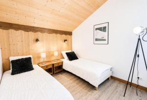 a bedroom with two beds and a desk with a lamp at Résidence Geffriand - Triplex pour 10 personnes proche des pistes au coeur des 3 Vallées MAE-4944 in Levassaix