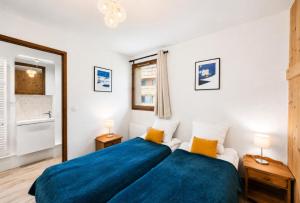 a bedroom with a bed with blue sheets and yellow pillows at Résidence Geffriand - Triplex pour 10 personnes proche des pistes au coeur des 3 Vallées MAE-4944 in Levassaix +13 photos