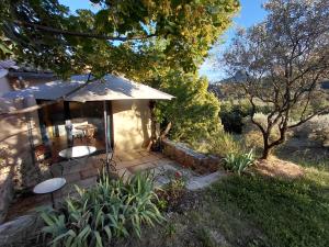a house with a patio with a table and chairs at La Maisonnette Veyronne - Gîte neuf in Aubres