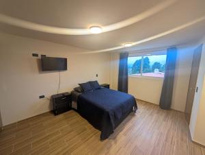 a bedroom with a bed and a flat screen tv at Casa Terraza Zacatlan in Zacatlán