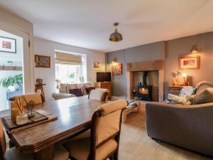 a living room with a wooden table and a living room with a fireplace at Sunnyside in Matlock