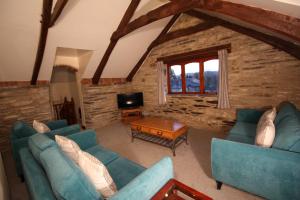 a living room with blue couches and a tv at David's Organic Farm Wales in Llanfallteg