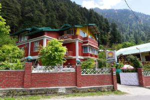 a red brick building in front of a mountain at Hotel O by OYO Manali Meadows Home Stay in Manāli +18 photos