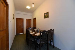 a dining room with a table and chairs at Hotel O by OYO Manali Meadows Home Stay in Manāli