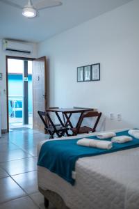 a bedroom with a bed and a table in it at Di Villa Búzios in Búzios