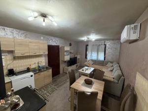 a living room and kitchen with a couch and a table at Tara Holiday Home in Mojkovac
