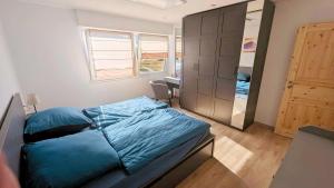a bedroom with a bed and a desk and a cabinet at Ferienwohnung Wittle in Weiler-Simmerberg