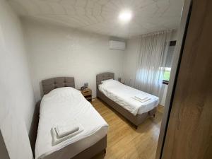 two beds in a small room with white sheets at Tara Holiday Home in Mojkovac +24 photos