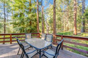 a table and chairs on a deck with trees at Idyllwild Glory Days in Idyllwild
