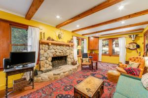 a living room with a stone fireplace and a tv at Idyllwild Glory Days in Idyllwild