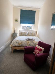 a bedroom with a bed and a couch and a window at Caroline's House in Swanage