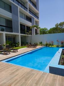 a swimming pool in front of a building at Departamento en Monné in Mérida